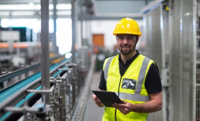 Portrait of smiling factory worker using a digital tablet