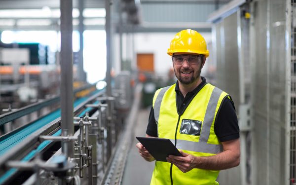 Portrait of smiling factory worker using a digital tablet